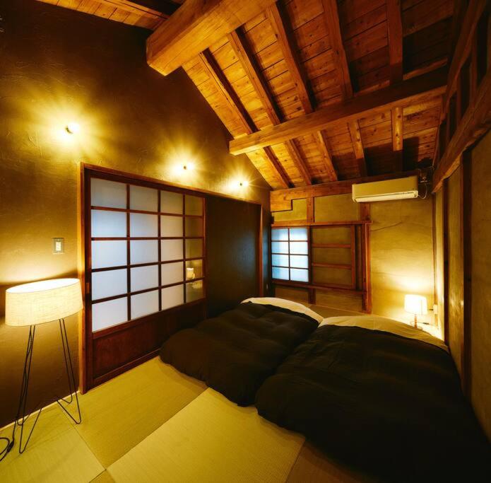 a bedroom with a large bed and a window at MUSIRO STAY and SAUNA 