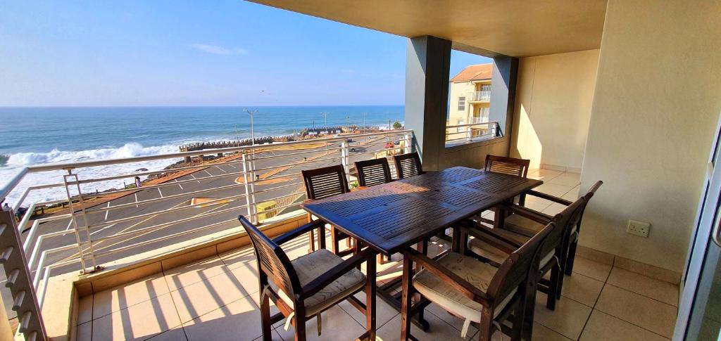 un comedor con mesa y sillas y el océano en La Mer 8 - 6 Sleeper - Overlooking Margate Beach! en Margate