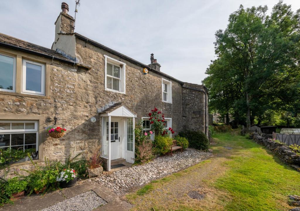 an old stone house with a white door at Long View in Kettlewell