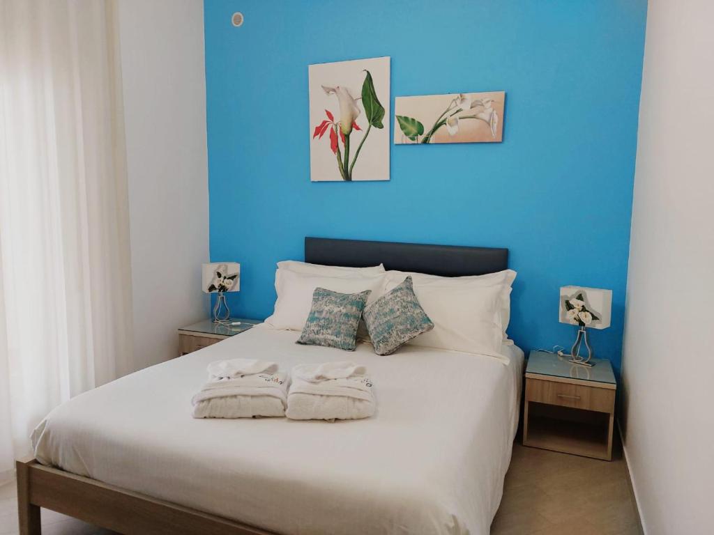 um quarto azul com uma cama branca e 2 almofadas em Colibri B&B em Sciacca