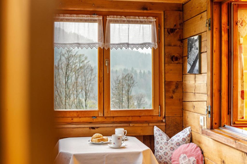 Zimmer mit einem Tisch, einem Fenster, einem Tisch und Stühlen in der Unterkunft Ferienhaus Dünser in Bizau