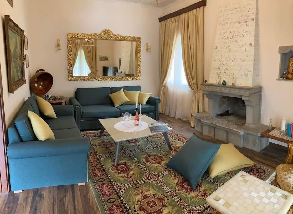 sala de estar con sofá azul y mesa en Yiayias House Tzoumerka, en Plaka