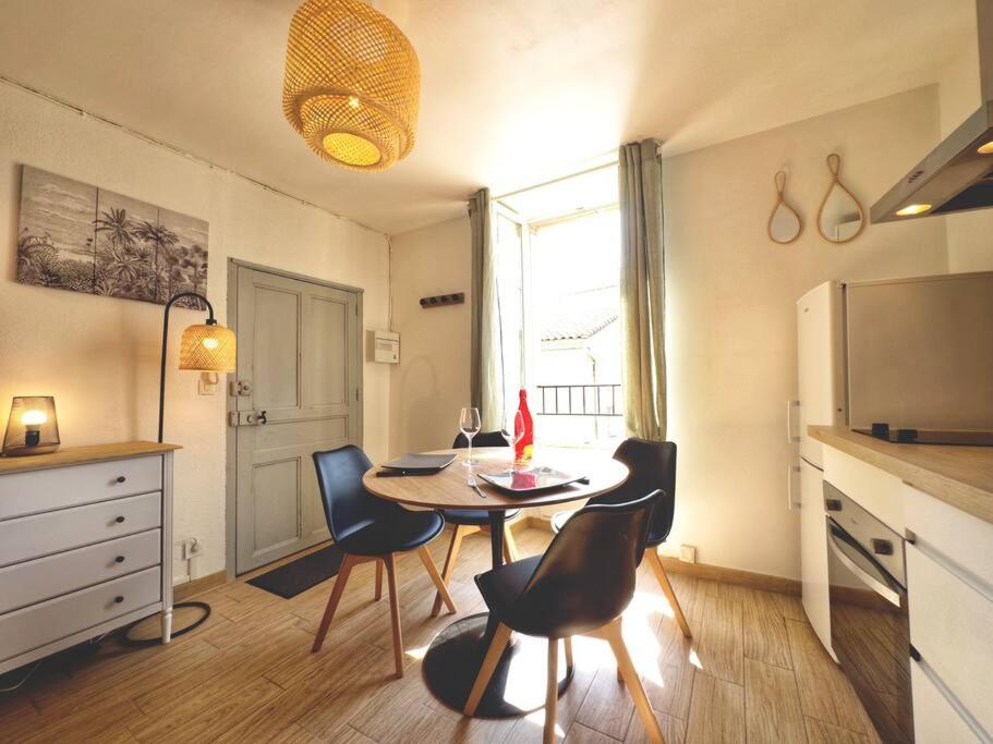- une cuisine avec une table et des chaises dans la chambre dans l'établissement Charmant studio à 200m du Gardon, à Remoulins
