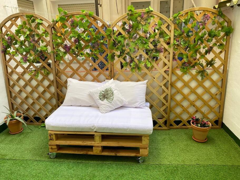 Bett in einem Zimmer mit einem Zaun mit Pflanzen in der Unterkunft Apartamento acogedor en Logroño in Logroño