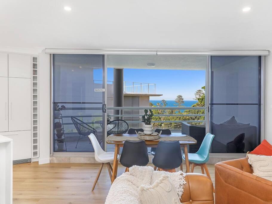 een woonkamer met een tafel en stoelen bij Lavish 3-bedroom ocean apartment in Wollongong in Wollongong