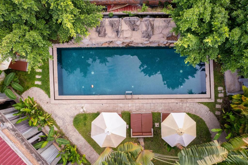 an overhead view of a swimming pool with two umbrellas at Maison Gen Angkor in Siem Reap