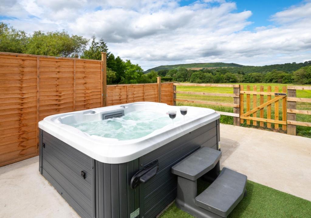 a hot tub on a patio with a fence at Little Haven in Easby