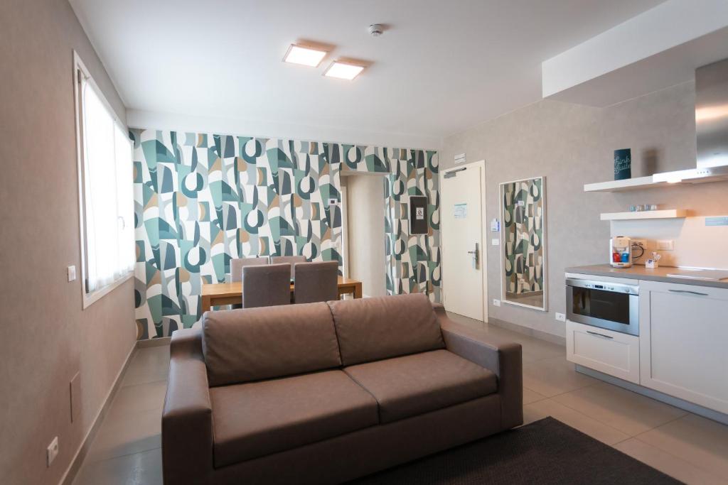 a living room with a couch and a kitchen at Mosella Suite Hotel in Sottomarina