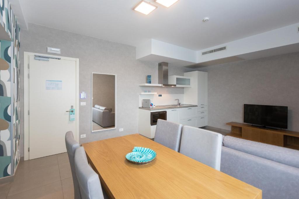 a dining room with a wooden table and chairs at Mosella Suite Hotel in Sottomarina