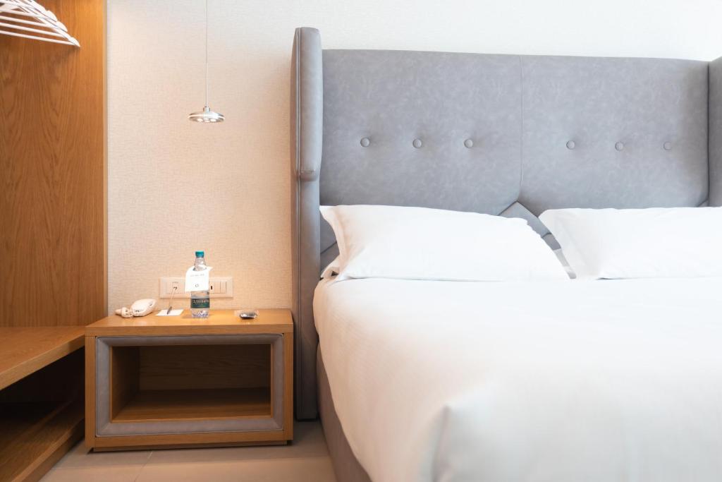 a bedroom with a bed and a table with a bottle of water on it at Mosella Suite Hotel in Sottomarina
