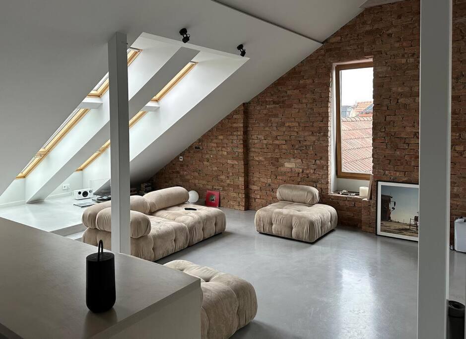 a living room with couches and chairs in a loft at Raguvos Apt. in Kaunas