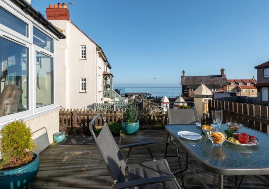 a patio with a table and chairs and the ocean at Lezayre in Sandsend