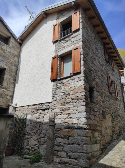 un antico edificio in pietra con finestra e balcone di Residenza Campagnano a Musignano