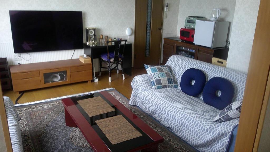 een woonkamer met een bank en een tv bij 旅の宿ていね in Sapporo
