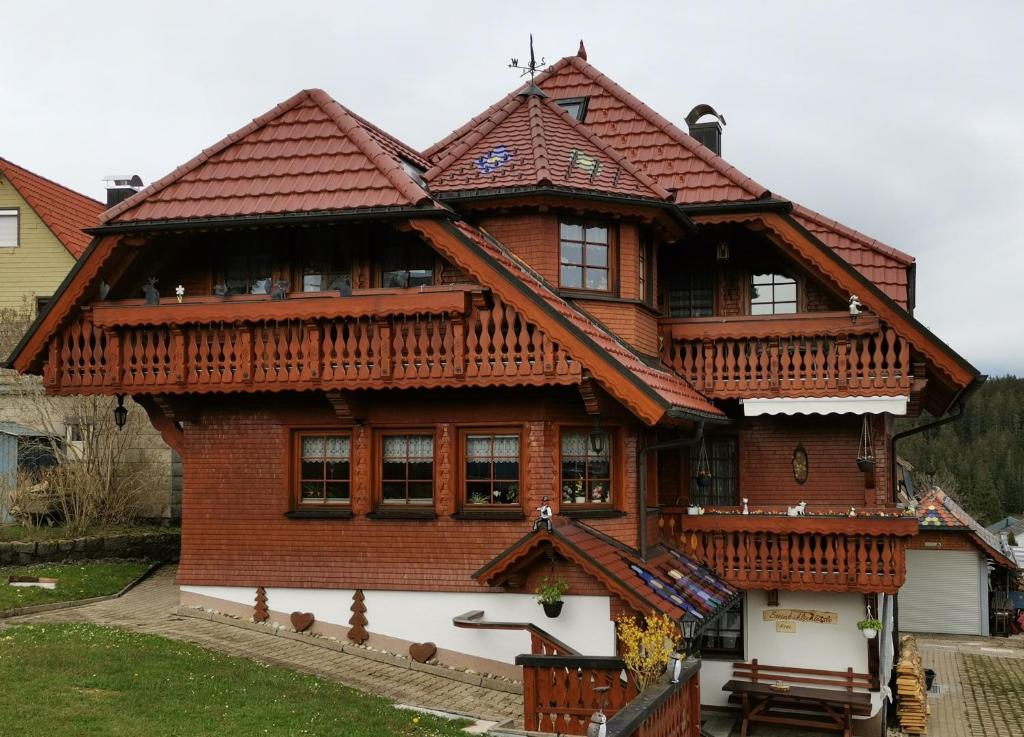 a large wooden house with a wooden roof at Steinbühlschlössle in Schönwald