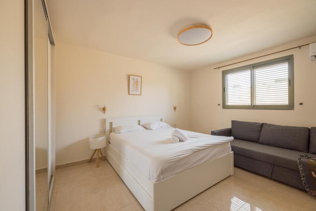 a bedroom with a bed and a couch at Shifra Suite in Beer Sheva