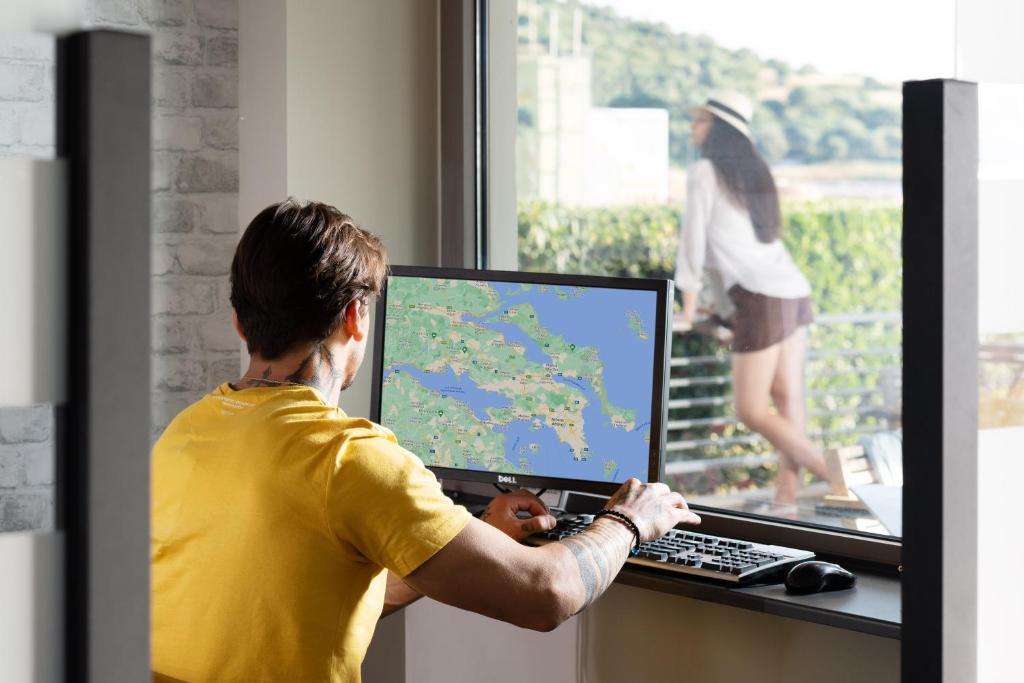 a man using a computer with a map on the screen at Akti Toroni Boutique Hotel in Toroni