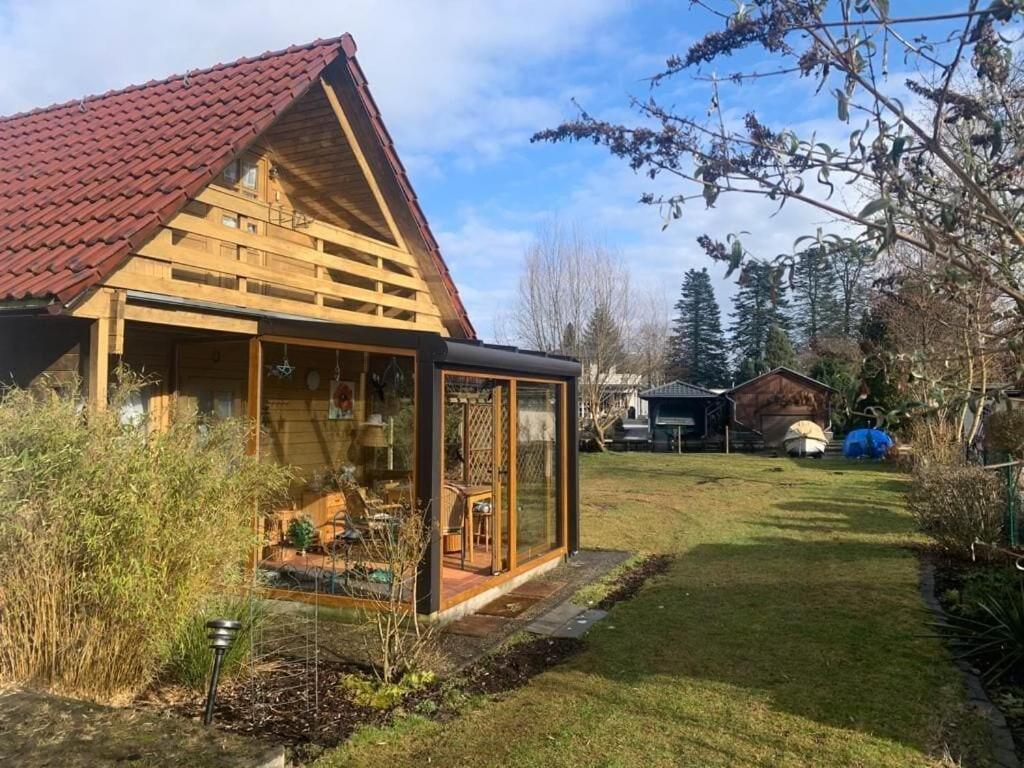 a cabin with a glass door in a yard at Ferienhaus mit direktem Wasserzugang in Berlin-Köpenick in Berlin