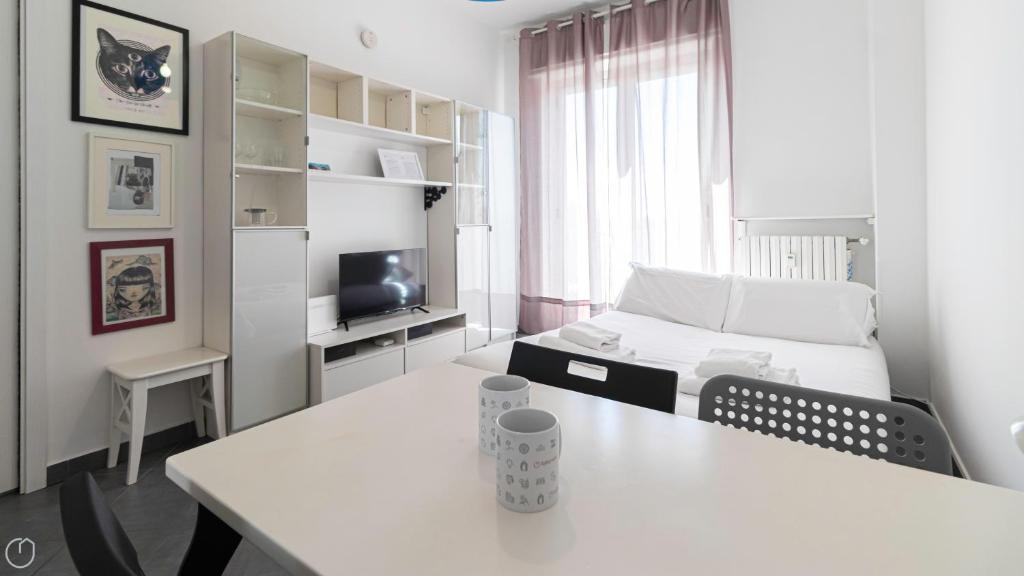 a white room with a white table and a bed at Italianway - Voghera 11 B in Milan