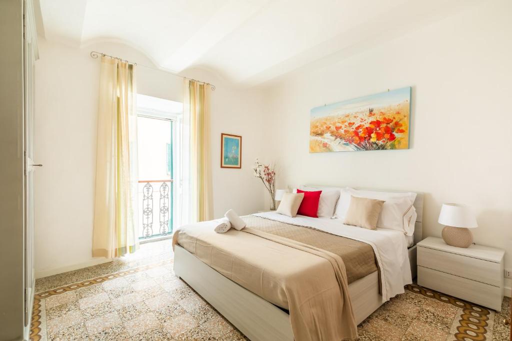 - une chambre blanche avec un grand lit et une fenêtre dans l'établissement Noi 2 Vacanze ORBETELLO CENTRO, à Orbetello
