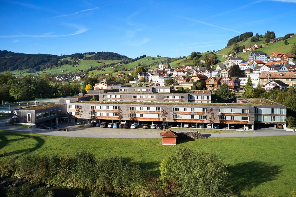 eine Gruppe von Gebäuden auf einem Hügel mit einer Stadt in der Unterkunft Reka-Feriendorf Urnäsch in Urnäsch