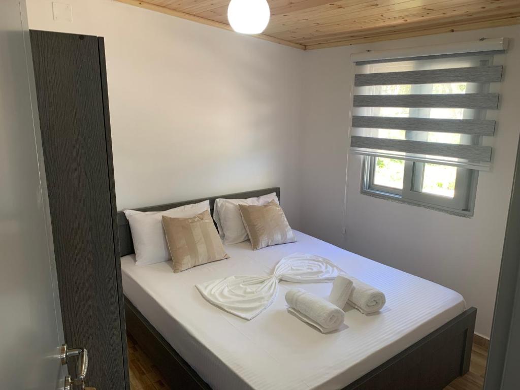 a bed with white blankets and pillows on it at Villa Ermali in Ksamil