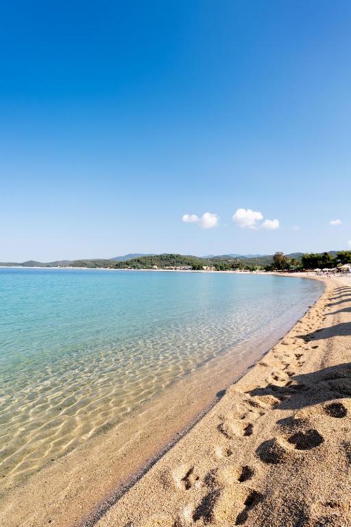 a beach with footprints in the sand and the water at Akti Toroni Boutique Hotel in Toroni
