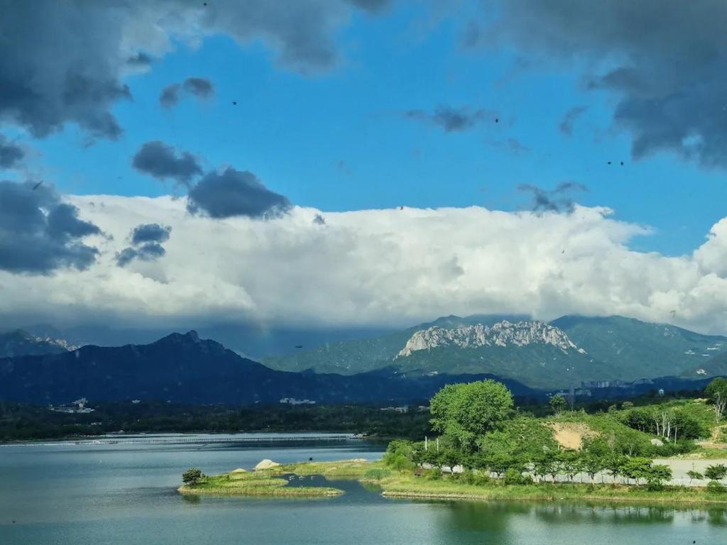 uma ilha na água com montanhas ao fundo em Lakestone&Hotel Sokcho em Sokcho