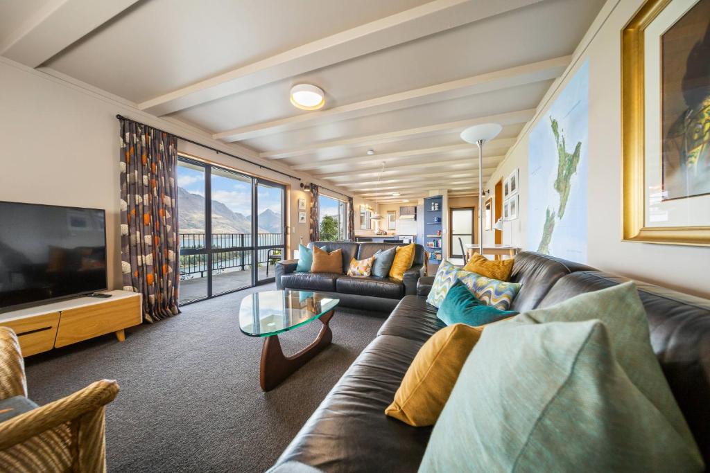 a living room with a couch and a tv at Whakatipu Heights in Queenstown
