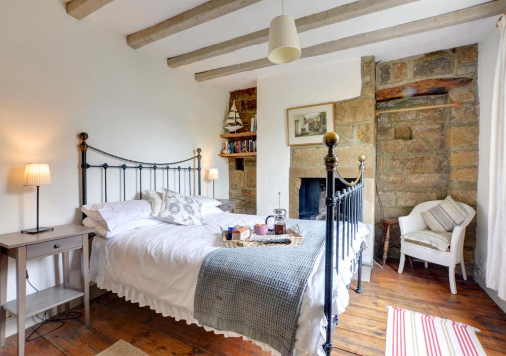a bedroom with a bed and a stone wall at Holmlea in Robin Hood's Bay