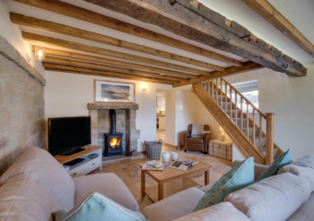 a living room with a couch and a fireplace at Holly Tree Cottage in Aislaby