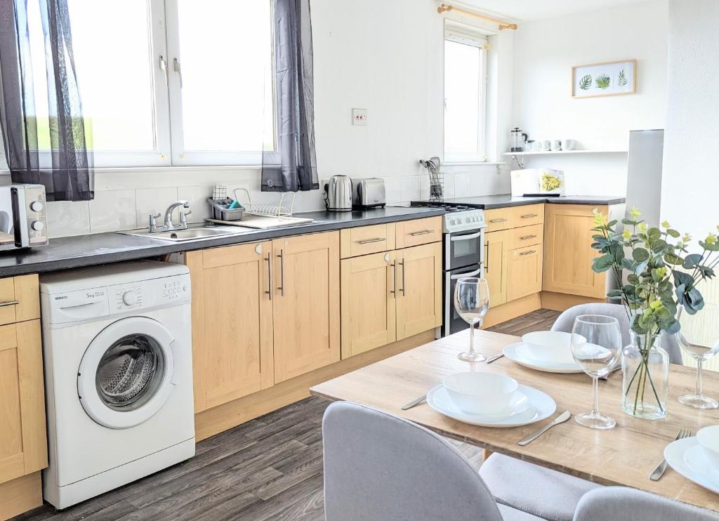 坎貝爾敦的住宿－Campbeltown Loch，厨房配有桌子和洗衣机。