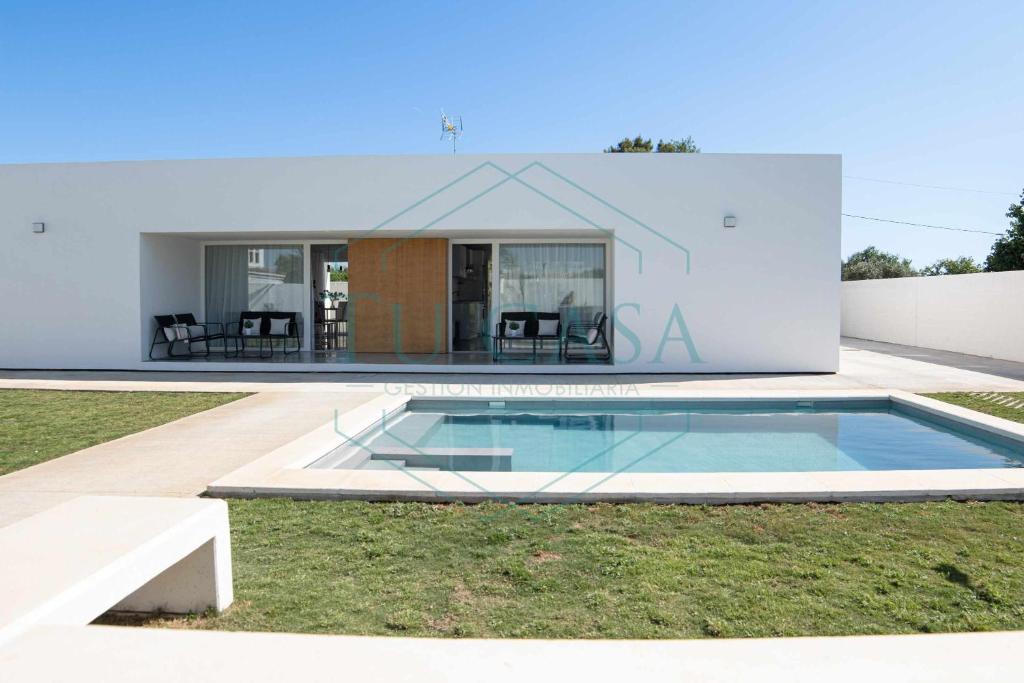 uma casa moderna com uma piscina no quintal em Villa Áurea em Cádiz