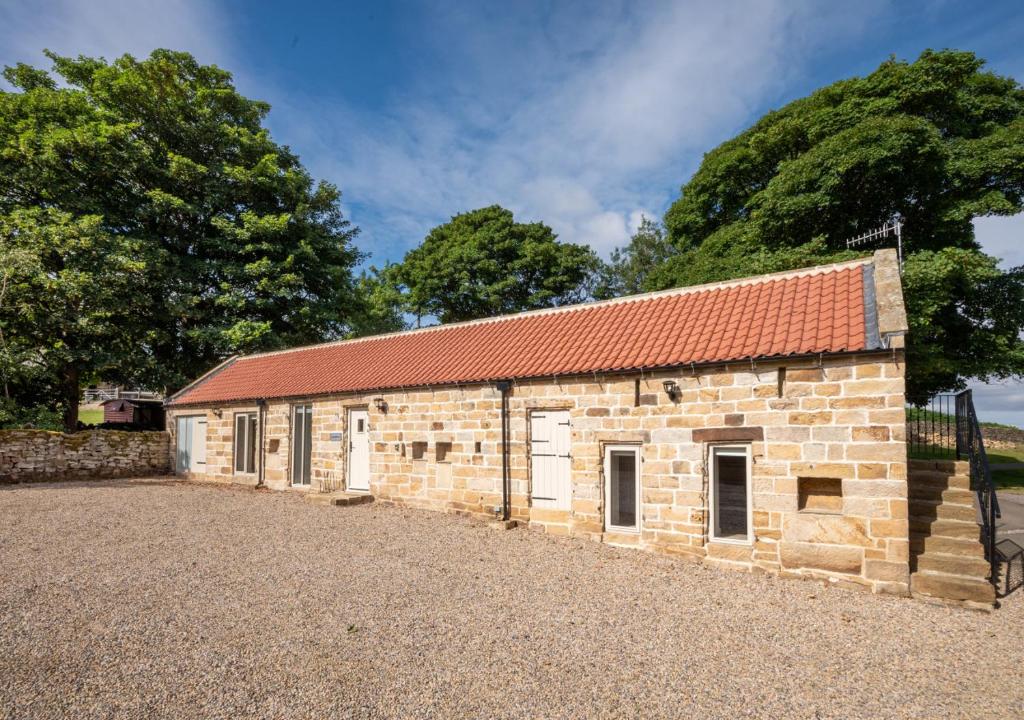 an old brick building with a red roof at Hog Barn at Howe End in Castleton