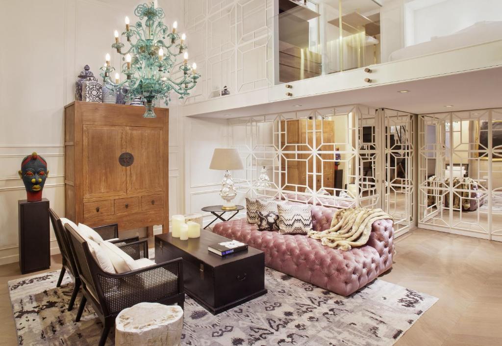 a living room with a pink couch and a christmas tree at Claris Hotel & Spa GL, a Small Luxury Hotel of the World in Barcelona