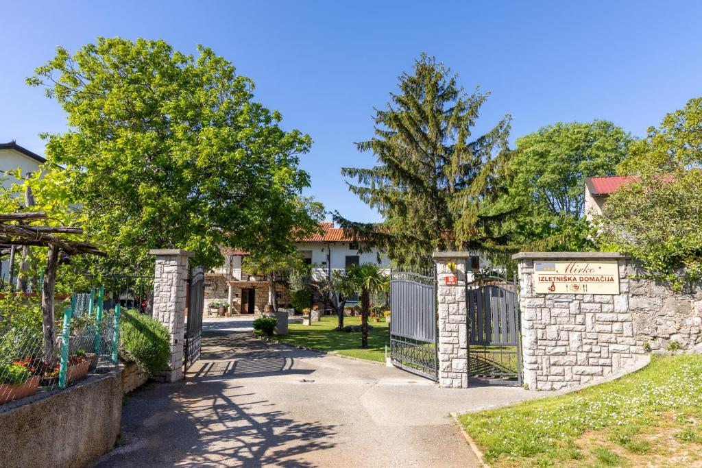 a gate in a yard with trees and a building at Domačija Mirko in Miren