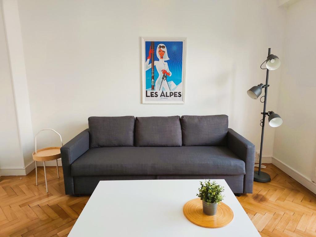 a living room with a couch and a table at Lumineux 2 Chambres avec Garage privé - Tram à 1 min in Grenoble