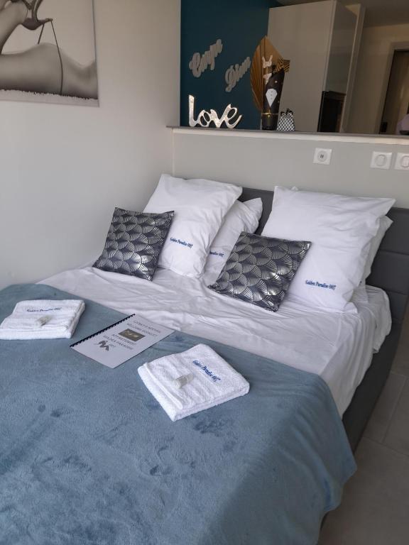 łóżko z poduszkami i certyfikatami na górze w obiekcie Golden Paradise 007 Port Nat w Cap d'Agde