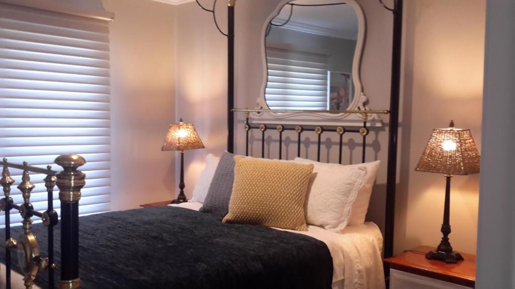 a bedroom with a bed with a mirror and two lamps at Camden Valley Terrace 4 