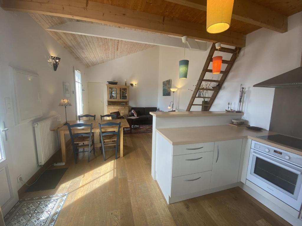 een keuken en een woonkamer met een tafel en stoelen bij Maison Fouras, 3 pièces, 4 personnes - FR-1-709-64 in Fouras