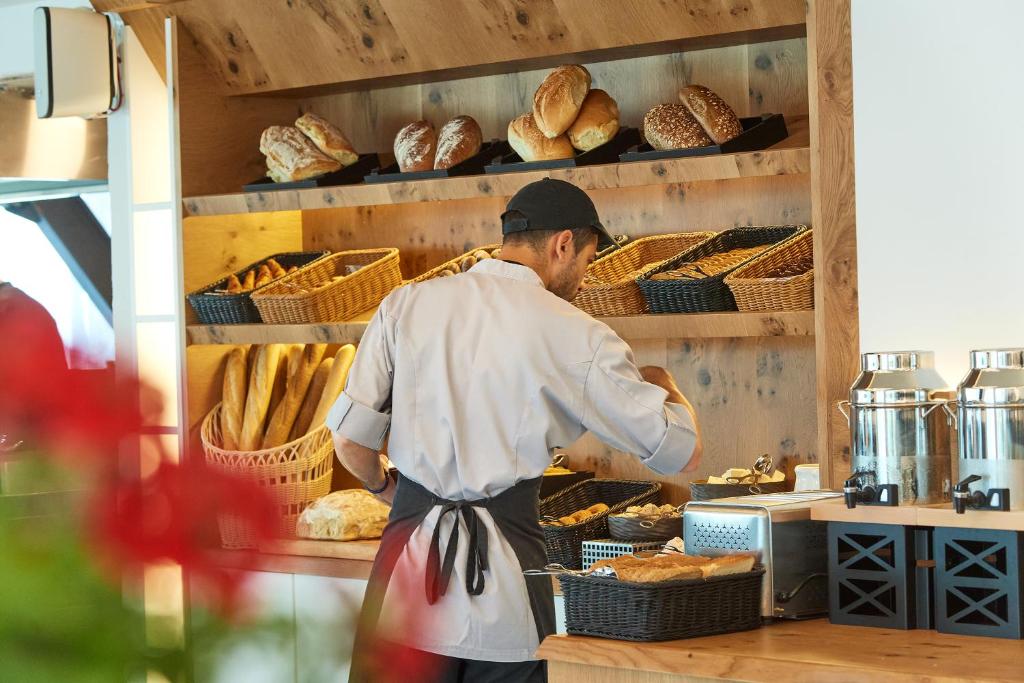a man is preparing bread in a bakery at Akti Toroni Boutique Hotel in Toroni
