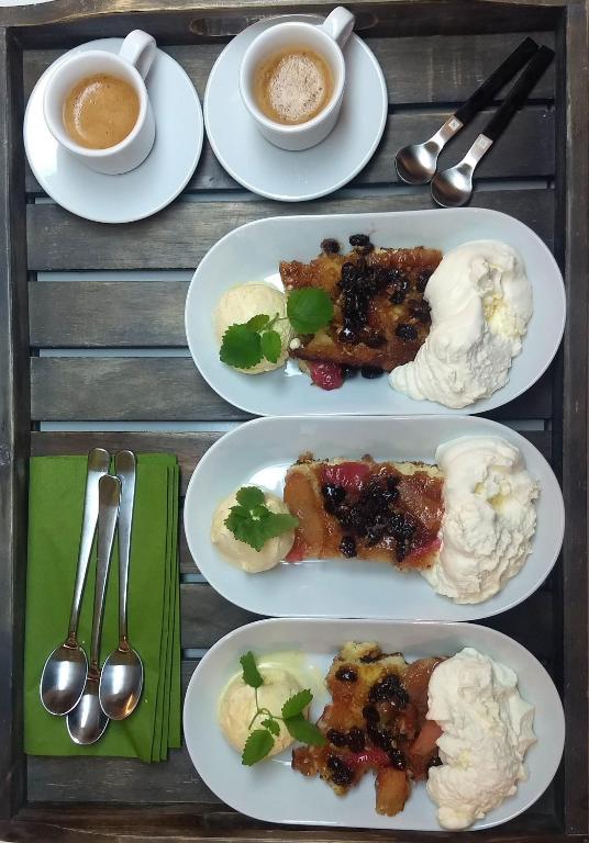 a table with plates of food and cups of coffee at Évika boutique hotel in Eskilsby