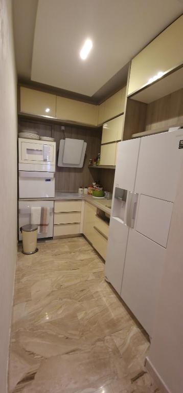 eine Küche mit einem weißen Kühlschrank und Geräten in der Unterkunft Tree cane apartman in Budva