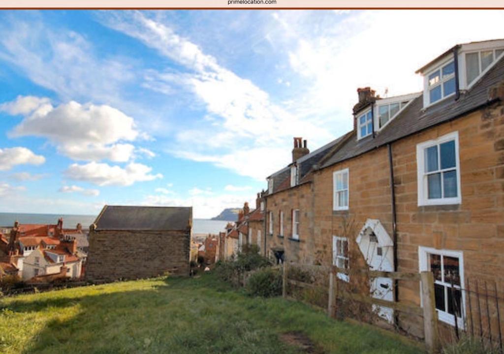 a brick house with a view of the ocean at Hillside in Robin Hood's Bay