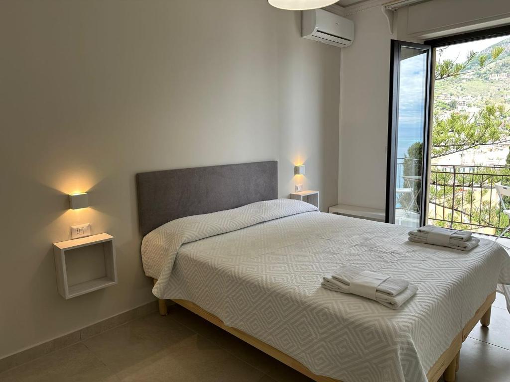 a bedroom with a bed with two towels on it at MIRA taormina rooms in Taormina