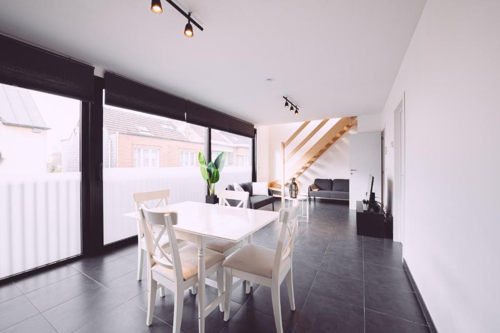 een eetkamer met een witte tafel en stoelen bij K&Y suites 1,Brussels airport 500m in Zaventem