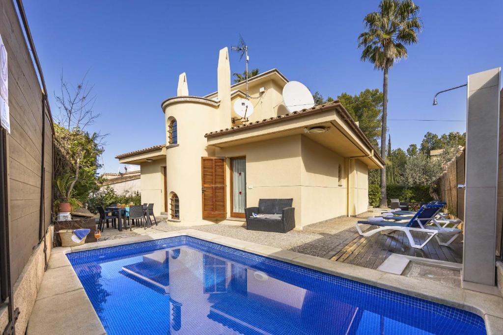a house with a swimming pool in front of a building at Can Quart in Alcudia