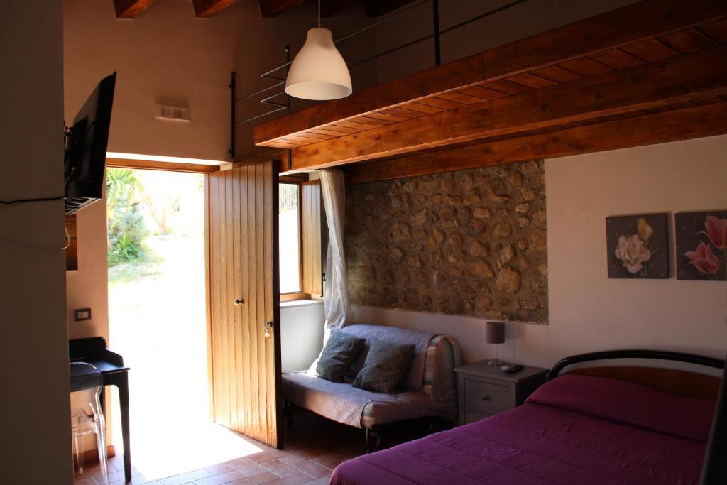 ein Schlafzimmer mit einem Bett, einem Stuhl und einem Fenster in der Unterkunft Roba Albanisi in Aragona