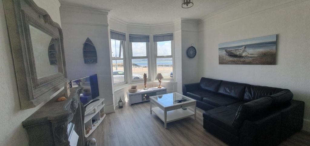 a living room with a couch and a tv at Ocean View in Llandrillo-yn-Rhôs