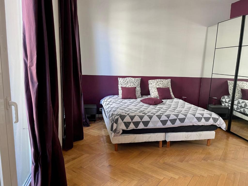 une chambre avec un lit avec un mur violet dans l'établissement Luminous Apartment golden quarter, à Marseille